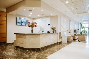 a lobby with a reception counter with flowers on it at Aparthotel Albufera in Alfafar +32 photos