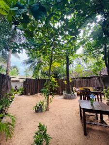 a patio with a wooden bench and a tree at Ocean Bliss in Pottuvil