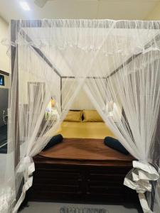 a small bed with mosquito netting in a room at Ocean Bliss in Pottuvil +17 photos