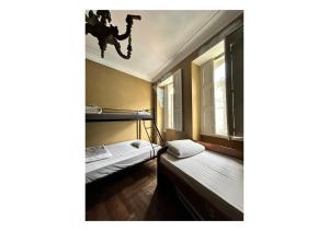 a small room with two beds and a chandelier at Casa Quixote, Centro Catedral in Braga +3 photos