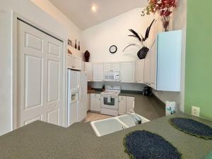 a kitchen with white cabinets and a white door at Right Direction Rentals Carnoustie Townhome in Port Saint Lucie