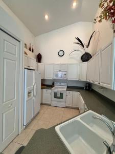 a kitchen with white cabinets and a white refrigerator at Right Direction Rentals Carnoustie Townhome in Port Saint Lucie
