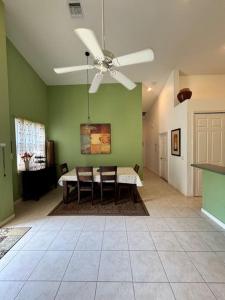 a living room with a table and a ceiling fan at Right Direction Rentals Carnoustie Townhome in Port Saint Lucie