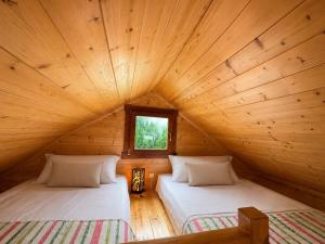 two beds in a log cabin with a window at Orla Chata Baltic House in Świnoujście +129 photos