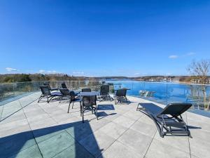 a patio with chairs and a table next to a body of water at Nad Zatoką Apartament 132 by Warmia4Rent, przy samej plaży miejskiej in Olsztyn