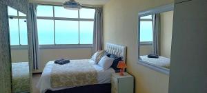 a bedroom with a bed with a view of the ocean at Apartment on doonside Beach in Kingsborough +10 photos