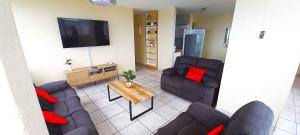 a living room with two couches and a flat screen tv at Apartment on doonside Beach in Kingsborough