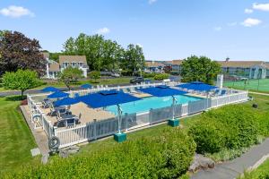 an outdoor swimming pool with blue umbrellas and chairs at The Sparhawk Oceanfront Resort in Ogunquit +57 photos