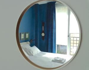 a mirror in a room with a bed and a window at Villa du Square, Luxury Guest House in Paris