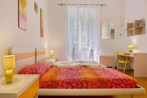 a bedroom with two beds and a desk and a window at Casa Mia in Rapallo