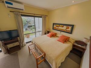 a bedroom with a bed and a flat screen tv at Hotel Los Sauces in Cafayate +109 photos