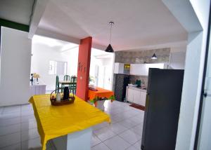 a kitchen with a yellow table and a yellow bench at Casa Rosi in Pitimbu +3 photos