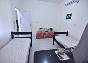 a living room with two beds and a table at Casa Rosi in Pitimbu