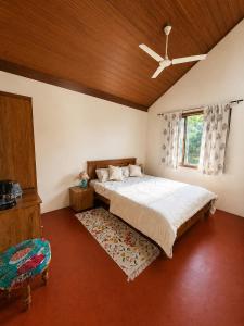 a bedroom with a bed and a ceiling fan at Priyaman Retreat in Madikeri