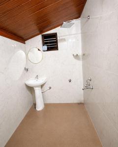 a bathroom with a sink and a mirror at Priyaman Retreat in Madikeri