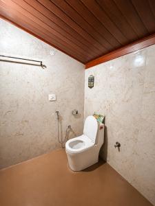 a bathroom with a toilet in a room at Priyaman Retreat in Madikeri +8 photos