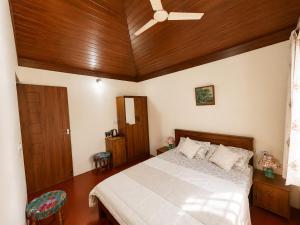 a bedroom with a bed and a ceiling fan at Priyaman Retreat in Madikeri