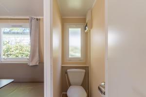 a bathroom with a toilet and a window at Mobil-home Le 154 aux Iscles in La Roque-dʼAnthéron