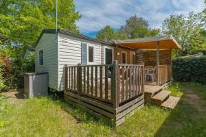a small cabin with a porch and a deck at Mobil-home Le 154 aux Iscles in La Roque-dʼAnthéron