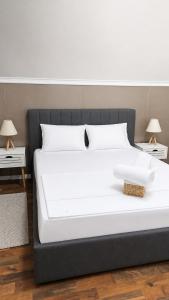 a large white bed with two tables and two lamps at Adori Apartment in Eforie Nord