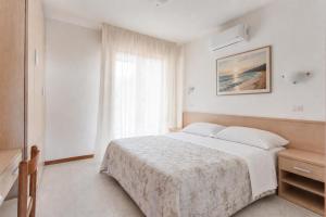 a bedroom with a large bed and a window at Aparthotel Costa Paradiso in Lido Adriano +42 photos