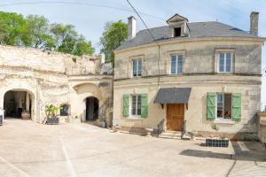 an old stone building with green windows and a door at Parnaydisiaque in Parnay +4 photos
