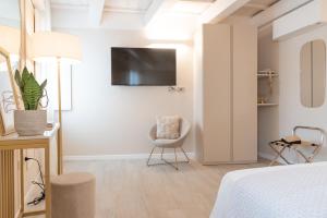 a bedroom with a bed and a chair and a tv at Residenza Isotta in Rimini
