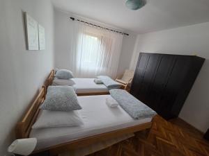 a room with four beds and a window at Apartments Valiza III Large apartment - 3 bedrooms and parking space i Apartments Valiza IV in Senj +157 photos