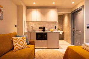 a living room with a couch and a kitchen at L anima II in Skiathos
