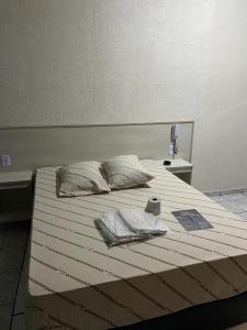 a bed with two pillows on top of it at Hotel São Mateus in São Paulo