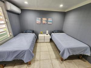 two twin beds in a room with aillin at Vista Azul Apartment in Punta Santiago