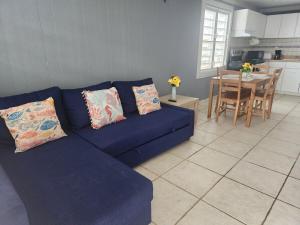 a blue couch in a living room with a table at Vista Azul Apartment in Punta Santiago