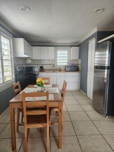 a kitchen with a table and chairs and a refrigerator at Vista Azul Apartment in Punta Santiago