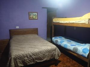 a bedroom with two bunk beds and a small bed at Loma Tika - Tilcara Hostel in Tilcara
