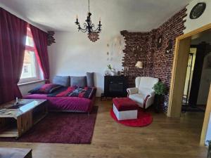 a living room with a couch and a brick wall at Magische Welt in Bautzen