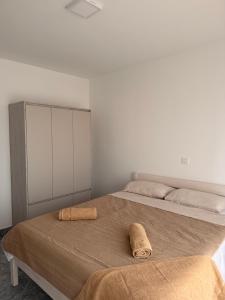 a bedroom with two beds with towels on the bed at Apartmani Gržeta in Vir