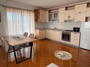 a kitchen with a table and chairs and a refrigerator at Apartmani Gržeta in Vir
