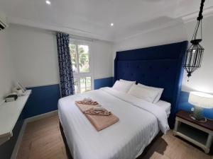 a bedroom with a large white bed with a blue headboard at Seven Seas Code di Azur in Na Jomtien +113 photos