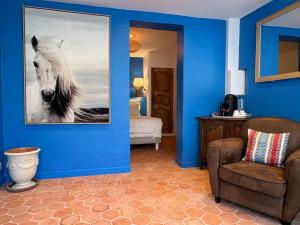 a blue room with a picture of a horse on the wall at Hôtel Le Neptune en Camargue in Saintes-Maries-de-la-Mer