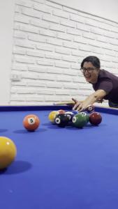 a woman sitting on a pool table with balls at Hotel Alojamiento Raque-Lito in Patquía