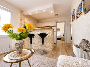 a living room with a vase of flowers on a table at Apartments Obradovic in Krašići