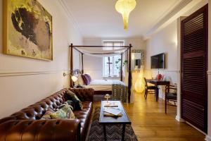 a living room with a leather couch and a bed at 66 Guldsmeden in Copenhagen