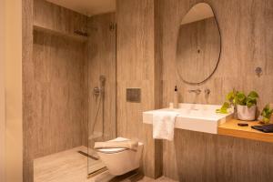 a bathroom with a toilet and a sink and a mirror at L anima II in Skiathos +30 photos