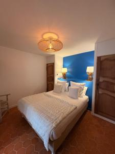 a bedroom with a large bed with a blue wall at Hôtel Le Neptune en Camargue in Saintes-Maries-de-la-Mer