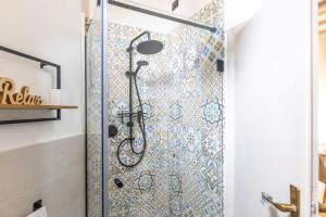 a shower in a bathroom with a mosaic wall at Italian Experience-La Terrazza nel Borgo in Marsciano +55 photos