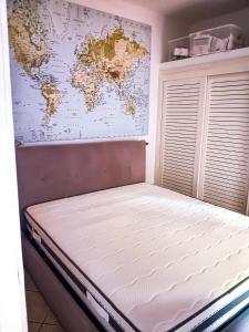 a bed in a room with a map on the wall at Casa di Luga in Costa Paradiso