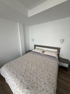 a bedroom with a bed with a floral bedspread at Guest House Nakjoski in Ohrid