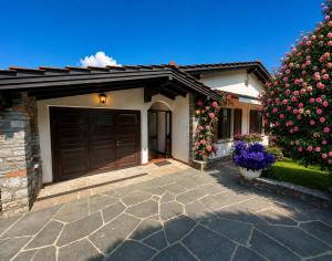 a house with a garage and a large tree with flowers at Lake View Palm Garden in Lugano