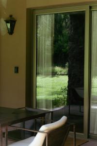 a room with a window with a table and a view of a yard at Casa Entonada - Hotel Boutique in Chacras de Coria