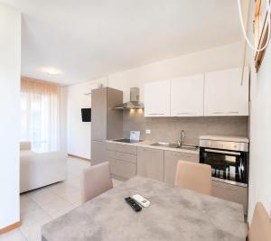 a kitchen with white cabinets and a table and chairs at Aparthotel Costa Paradiso in Lido Adriano